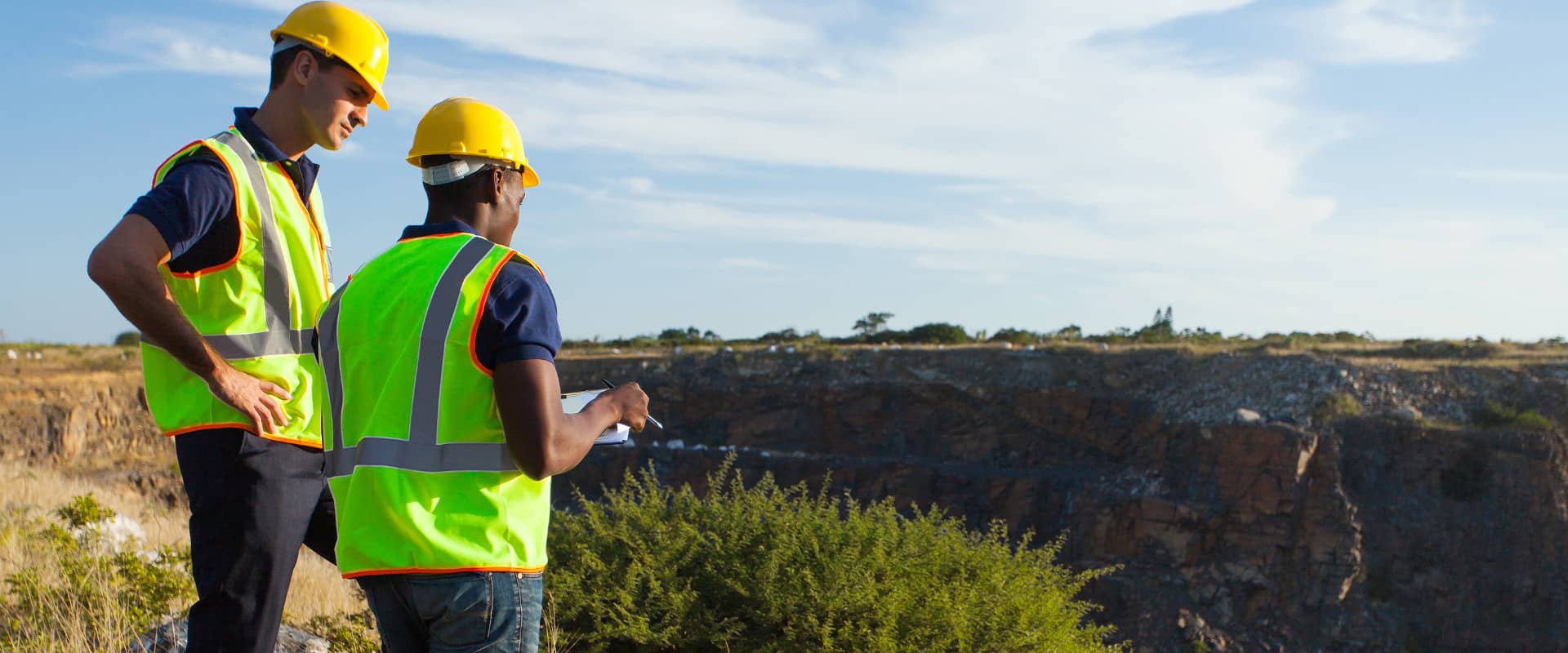 two male surveyors working at mining site